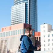 layout by flywheel responsive google map feature man on phone in front of skyline