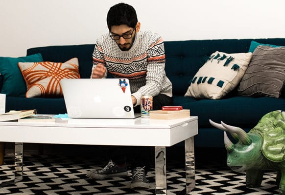 layout flywheel wordpress plugins essentials 2018 feature man on couch with laptop and blow up dinosaur