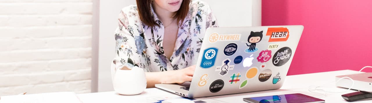 layout by flywheel how to create custom post templates wordpress woman working on laptop covered in stickers