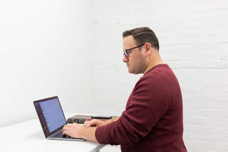 Man sits at desk and types on computer 