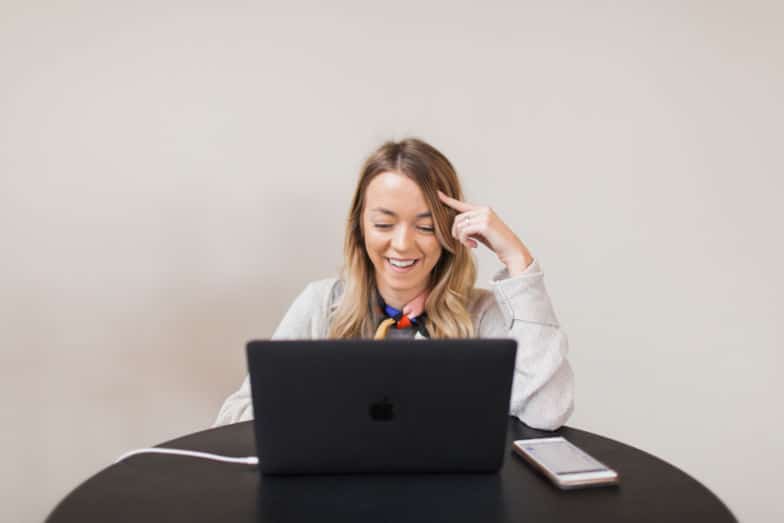 Woman smiles at a computer 
