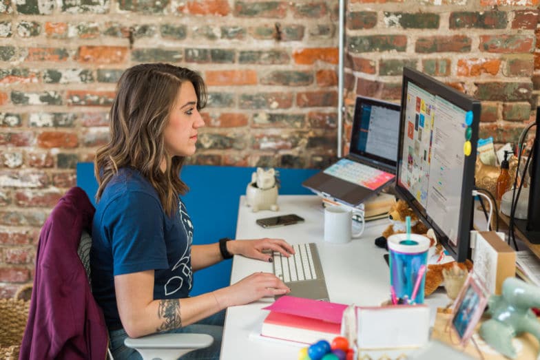 A woman works on a computer at a desk