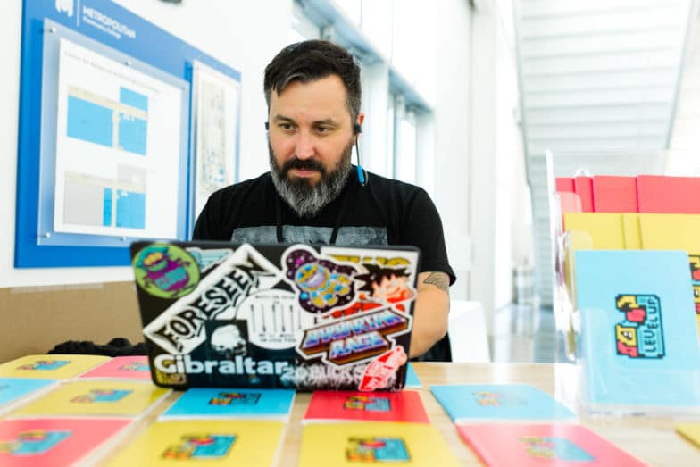 a web designer updates a WordPress site on a laptop covered in stickers