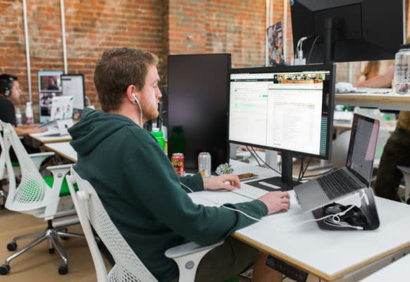 man working at a desk on a desktop computer