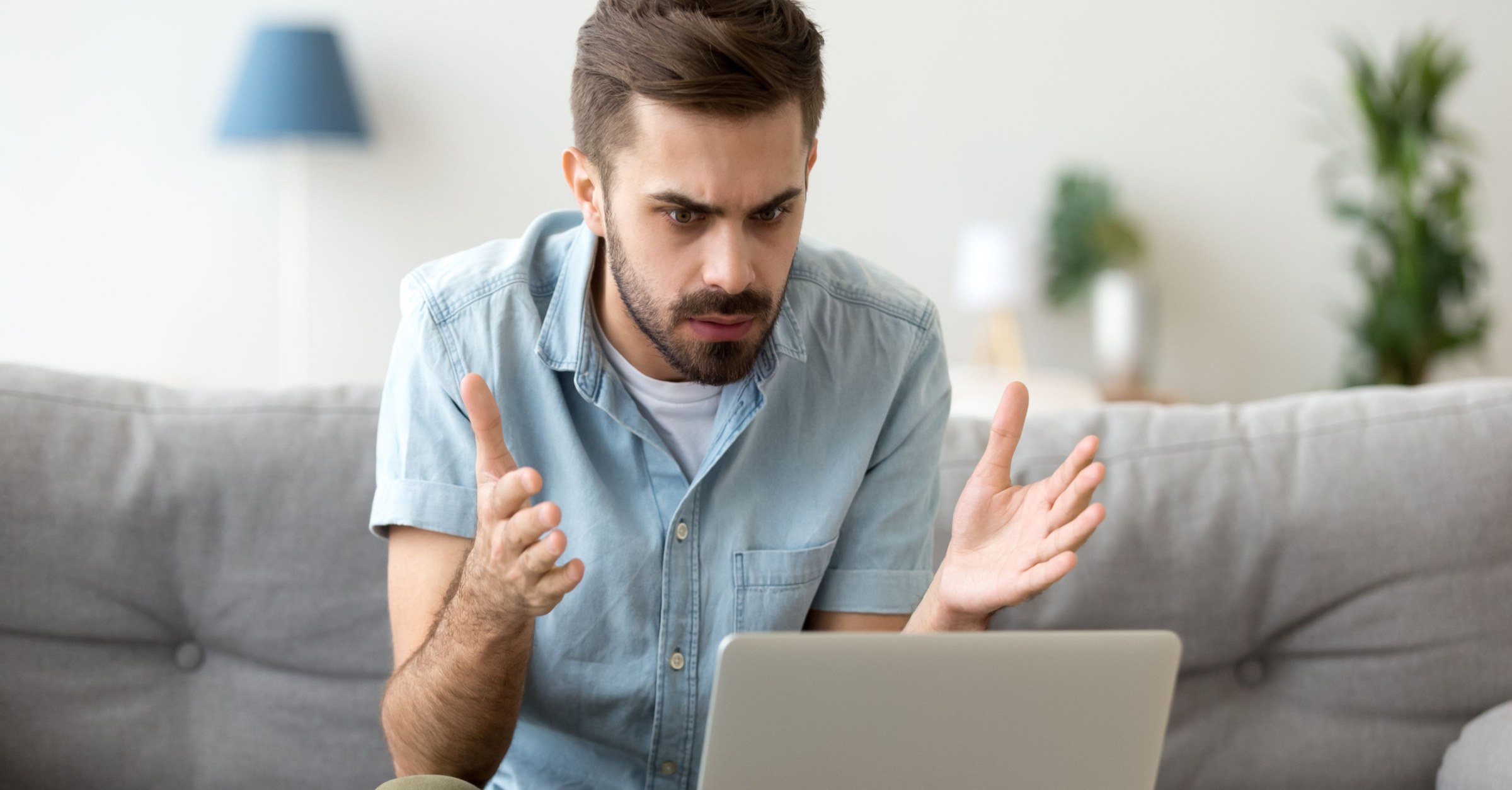 man sitting at computer looking frustrated