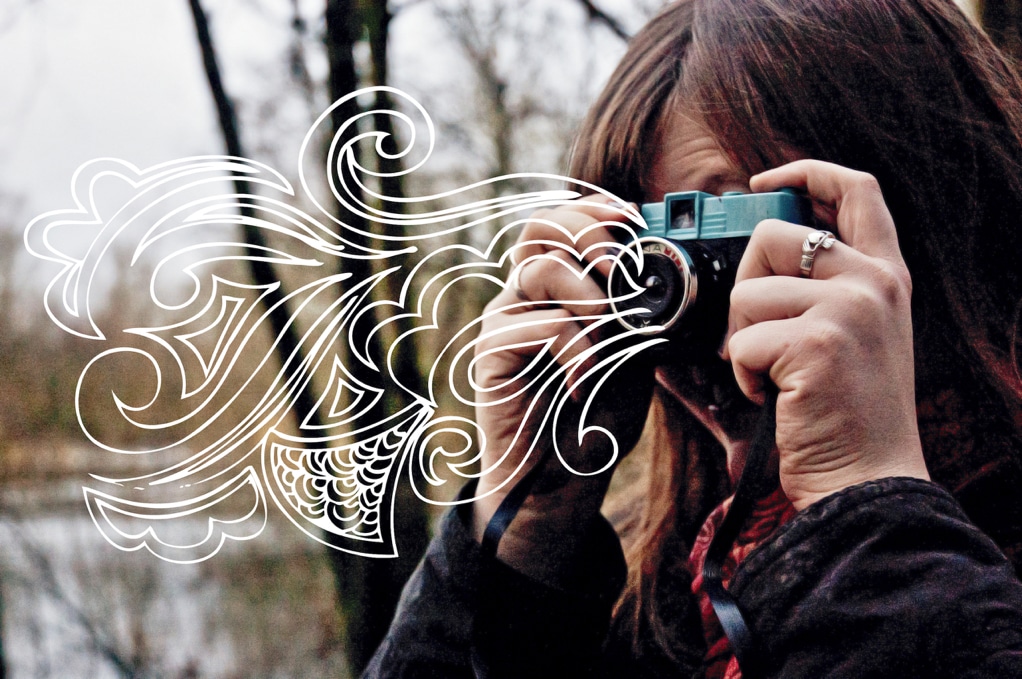 woman takes a picture with a camera, and white, expressive, illustrative, abstract linework erupts from the lens