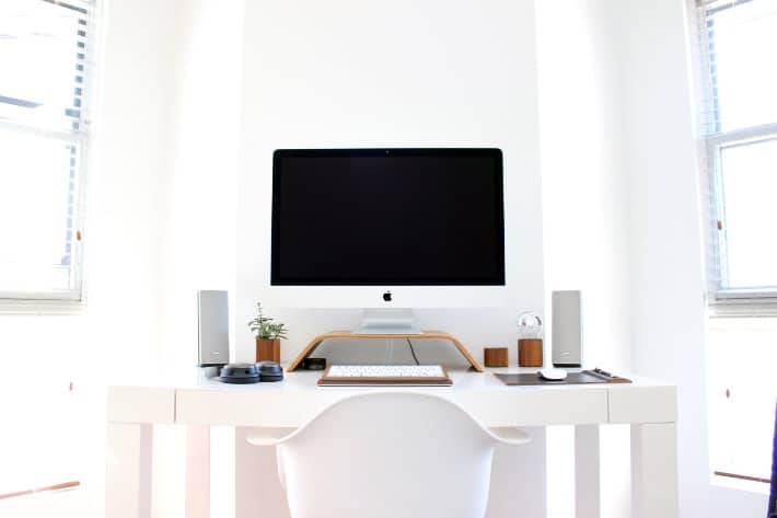 a computer desktop sits in a white office