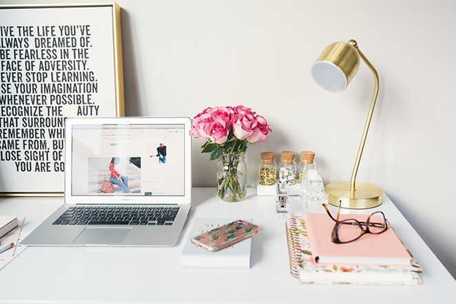 layout flywheel wordpress plugin essential 2018 list computer with blog on white and pink desk scene with lamp and flowers