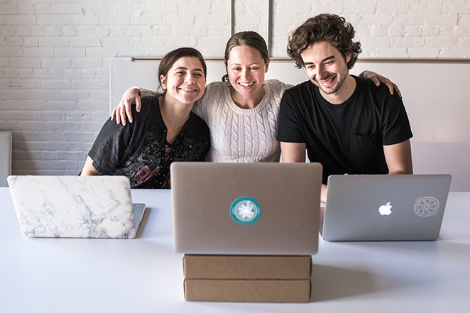 layout by flywheel freelancer pros and cons three people talking over laptops hugging