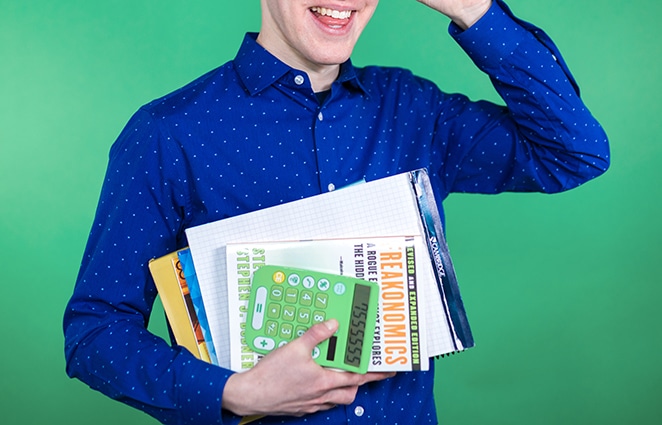 man in blue shirt with data and statistic books and calculator on green background