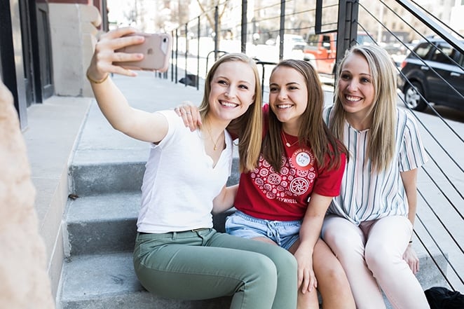 layout by flywheel inspiring Instagram accounts every marketer should follow three women taking selfie on concrete steps
