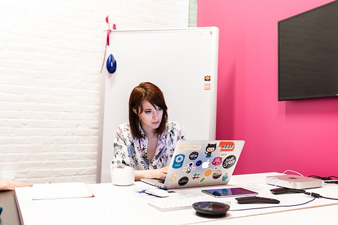 layout by flywheel how to create custom post template wordpress woman sitting at desk with laptop covered in stickers