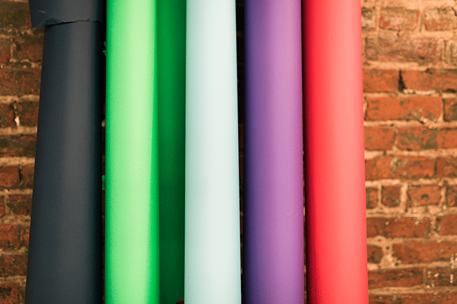 how to build a consistent brand across marketing channels with color backdrops leaning against brick wall